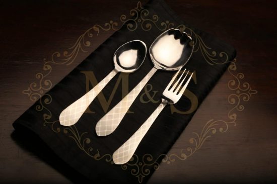 Teaspoon,rice serving spoon and fork placed on black cloth