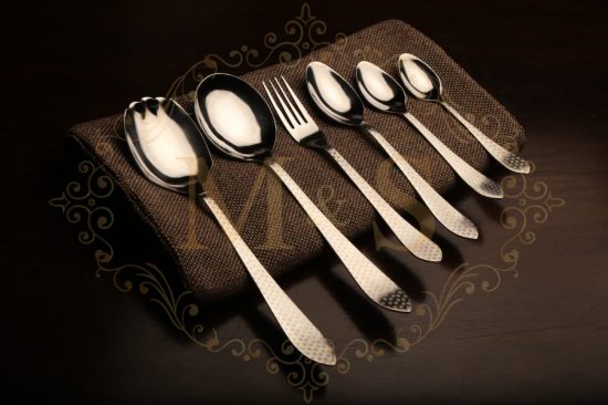 Complete aura essential polka cutlery set placed on brown cloth.