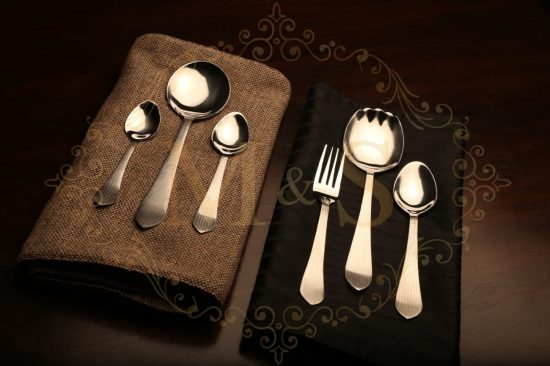 Complete aura essential square cutlery set placed on brown and black cloth.