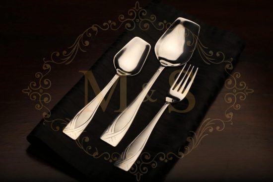 Table spoon,serving spoon and fork placed on the black cloth.