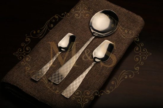 Tea spoon,serving spoon and tablespoon placed on a brown cloth.