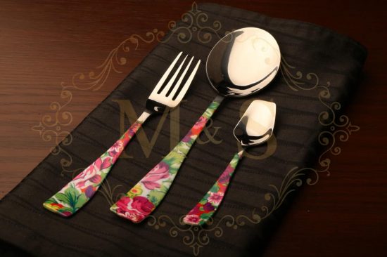 Fork,serving spoon and dessert spoon placed on the black cloth.