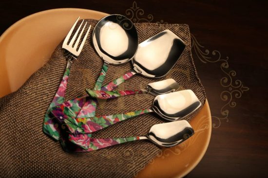 Cutlery set on the plate over brown cloth.
