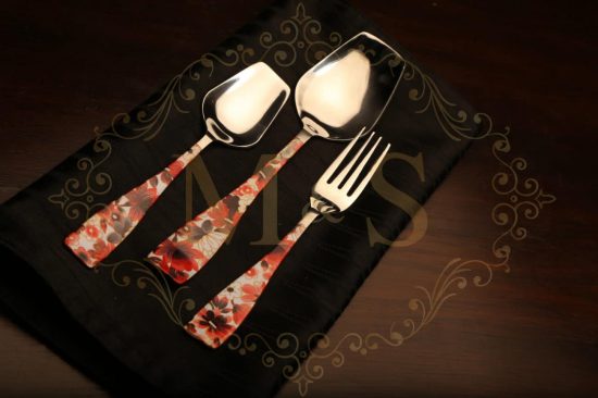 Table spoon,serving spoon and fork placed on black cloth.