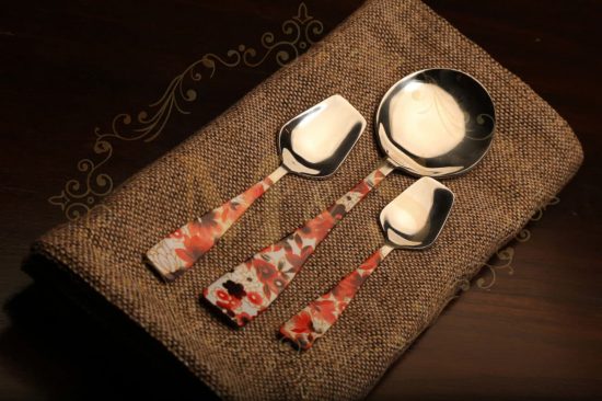 Tablespoon,serving spoon and teaspoon placed on brown cloth.