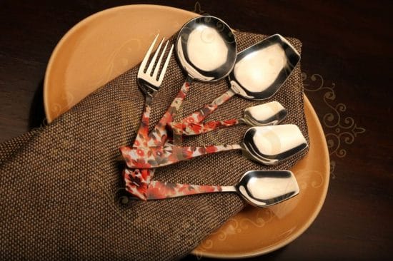 cutlery set on the plate over brown cloth.