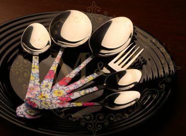 Complete aura fortune pearl cutlery set placed on black plate.