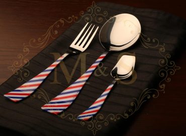 Fork,curry serving spoon and teaspoon placed on the black cloth.