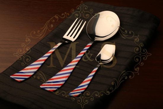 Fork,curry serving spoon and teaspoon placed on the black cloth.