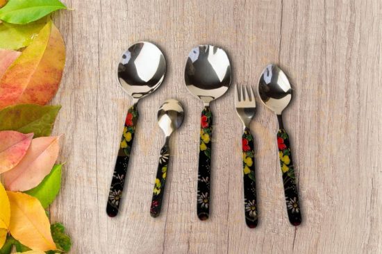 Serving spoons,tablespoon and fork placed on wooden board.